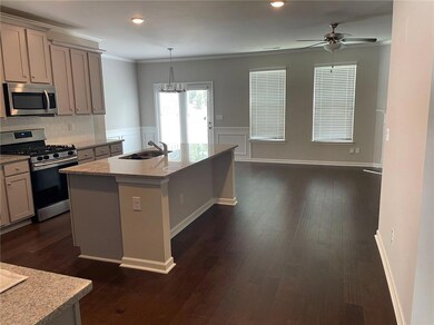 Kitchen with dark hardwood / wood-style floors, tasteful backsplash, an island with sink, stainless steel appliances, and sink
