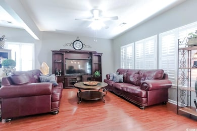 Living area with ceiling fan and wood finished floors