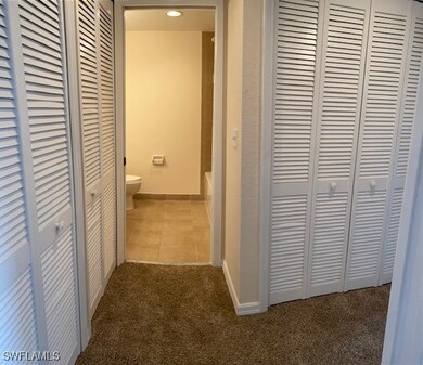 Corridor featuring baseboards, tile patterned floo