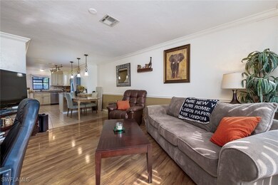 Living area featuring crown molding and light wood