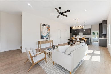 Living room featuring a chandelier, recessed lighting, light wood finished floors, and a ceiling fan