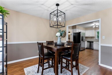 Dining area with large cased opening into the kitchen.  Updated light fixtures, hardwood floors.