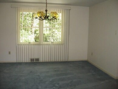 Spacious dining room with light fixture and hardwo