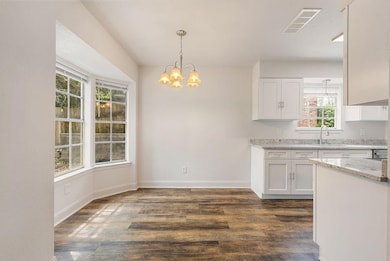 Kitchen with dark wood-type flooring, white cabine