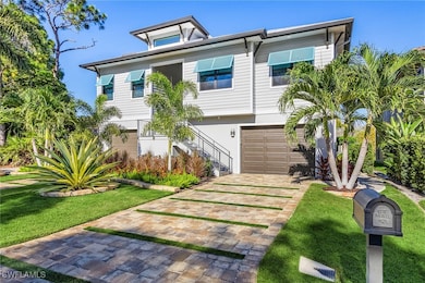 View of front of home featuring stairway, a front lawn, decorative driveway, and a garage