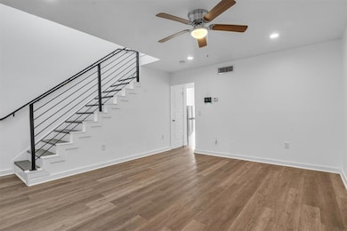 Unfurnished living room with stairway, wood finis