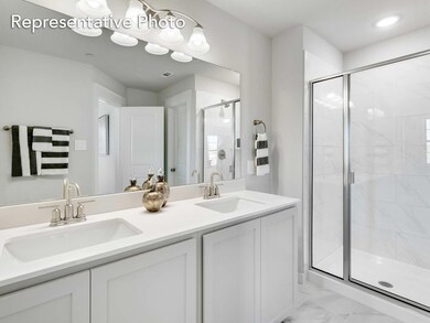Bathroom featuring tile flooring, dual sinks, an enclosed shower, and oversized vanity