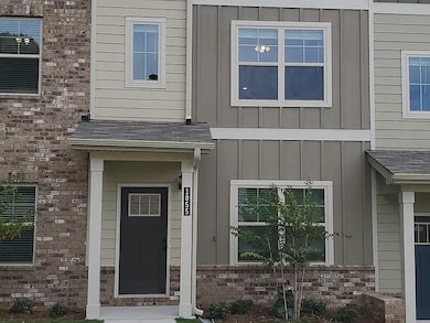 View of exterior entry featuring board and batten siding, brick siding, and roof with shingles