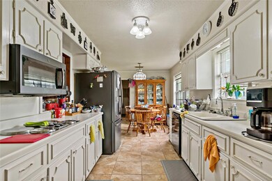 Kitchen with white cabinetry, sink, appliances wit
