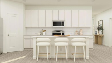 Kitchen featuring a kitchen bar, white cabinetry, 