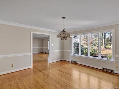 Large dining room with wood floor, chair rail, and