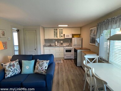 Kitchenette with subway tile back-splash and granite counters.