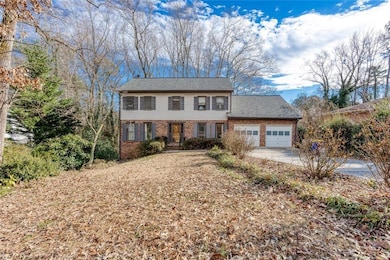 View of front of home with brick siding, an attached garage, and concrete driveway