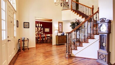 View from the formal living room of the Grand foyer and formal dining. Lots of natural light and handscraped wood floors. Full size outerwear closet under the staircase.