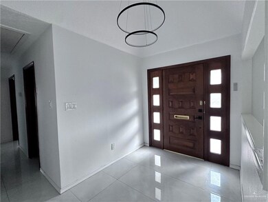 Foyer featuring baseboards, a wealth of natural light, and light tile patterned floors