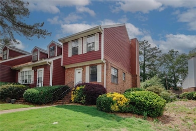 View of front of house with a front yard, a chimney, and brick siding