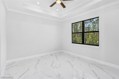 Empty room featuring a tray ceiling, ornamental mo