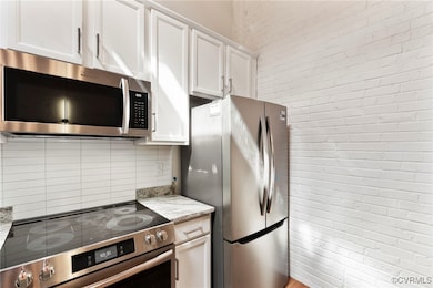 Kitchen featuring decorative backsplash, brick wal
