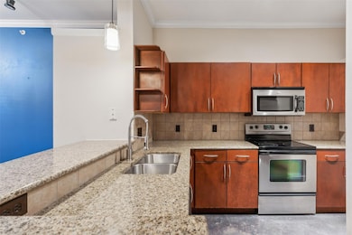 Kitchen with light stone countertops, sink, stainl