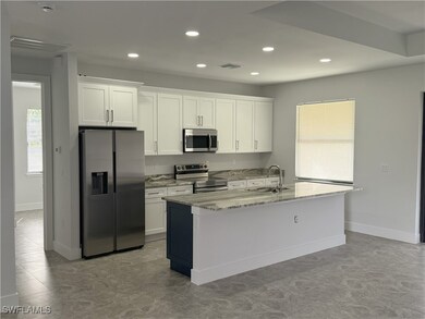 Kitchen with white cabinetry, visible vents, a kit