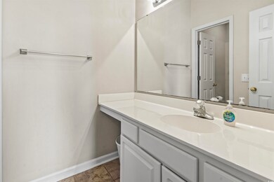 Bathroom featuring vanity, baseboards, and tile pa