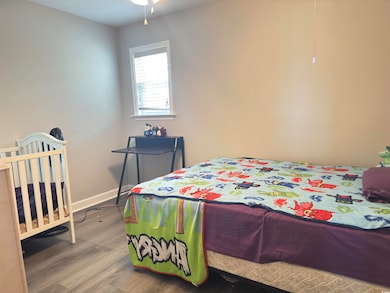 Bedroom with wood finished floors and baseboards