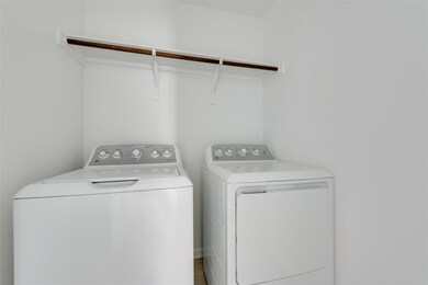 Laundry room featuring washing machine and clothes