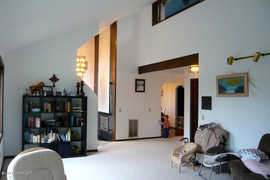 Sunken living room behind wall to left