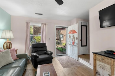 Living area with visible vents, baseboards, a ceil