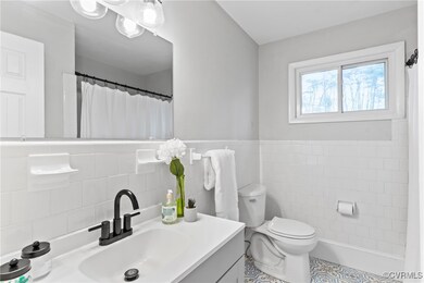 Full bath featuring newer tile walls, curtained sh