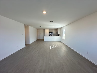 Unfurnished living room featuring dark wood finished floors and baseboards