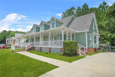 View of front facade featuring a porch, a front yard, and a shingled roof