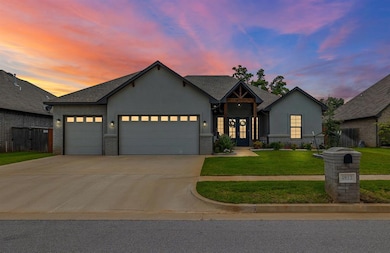 View of front of house featuring french doors, stucco siding, an attached garage, driveway, and a lawn