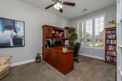 Office space with dark colored carpet and ceiling 