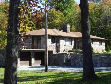 Exterior Front. cut stone home with retaining wall