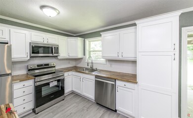 Kitchen featuring crown molding, sink, tasteful ba