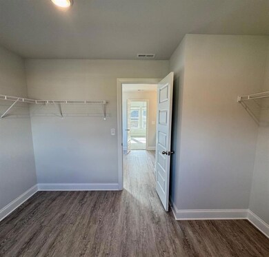 Spacious closet featuring visible vents and wood f