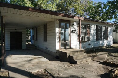 View of front of home featuring a carport and cool