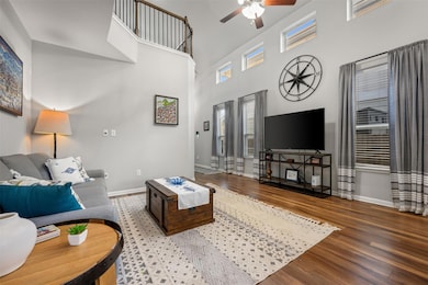 Living room featuring baseboards, a ceiling fan, 