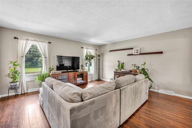 Living room with a wealth of natural light, hardwood / wood-style flooring, and a textured ceiling