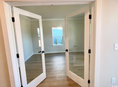 Interior space with crown molding, baseboards, and
