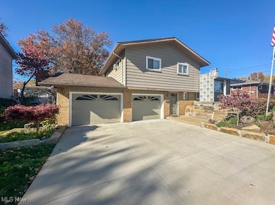 Tri-level home with brick siding and driveway