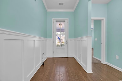 Doorway with dark wood-style floors, visible vents