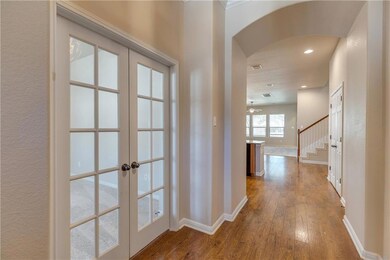 Hall with french doors, arched walkways, baseboar