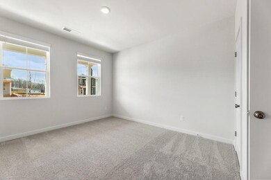 Carpeted spare room featuring baseboards