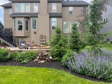 Lush landscaping surrounds firepit, patio and comp
