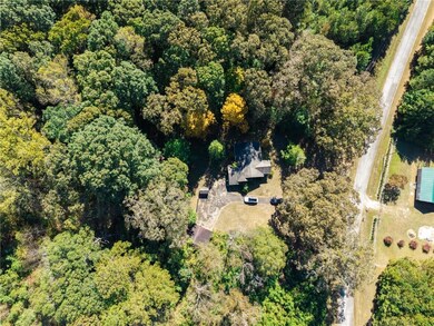 Aerial view of property and surrounding area featuring a heavily wooded area