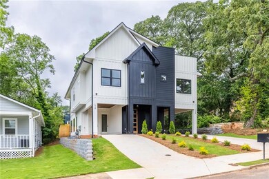 Modern farmhouse style home featuring a carport, driveway, board and batten siding, and a front yard
