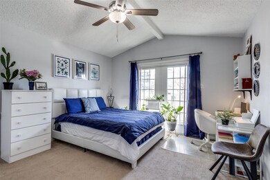 Bedroom featuring vaulted ceiling with beams, ceil