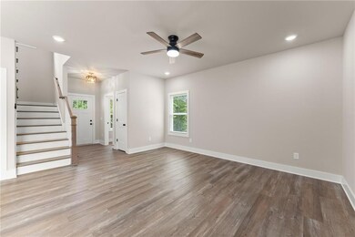 Unfurnished living room featuring wood finished floors, a ceiling fan, recessed lighting, and stairs